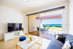 a living room with a blue couch and a table at Villa Hera in Nea Dimmata