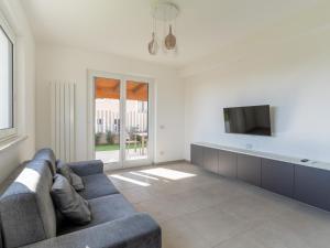 een woonkamer met een bank en een tv bij Rupes House in Roccella Ionica