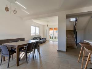 een eetkamer en woonkamer met een tafel en stoelen bij Rupes House in Roccella Ionica
