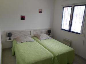 ein Schlafzimmer mit zwei Betten mit grüner Bettwäsche und einem Fenster in der Unterkunft Villa Fior 50 in Santa-Maria-Poggio + 41 Fotos