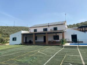 een huis met een parkeerplaats ervoor bij Cortijo Bachiller Alora 18 personas Fiestas tranquilas in Alora