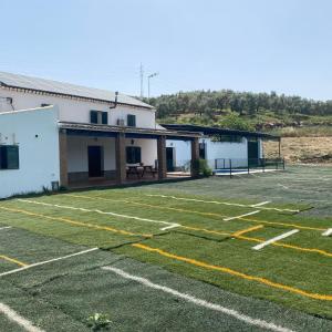 een leeg voetbalveld voor een gebouw bij Cortijo Bachiller Alora 18 personas Fiestas tranquilas in Alora