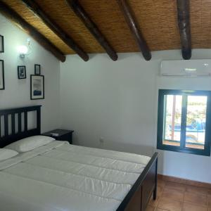 een slaapkamer met een groot bed en een raam bij Cortijo Bachiller Alora 18 personas Fiestas tranquilas in Alora +57 foto's
