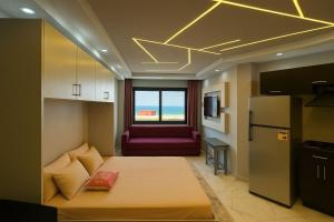 El-ManâkhEscape to a Luxury Chalet in Porto Said的一间带一张床的房间和一个带沙发的厨房 更多72张照片