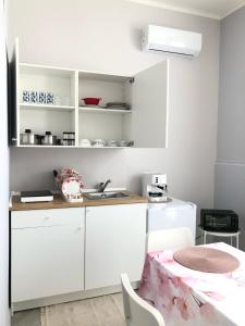 una cucina con mobili bianchi e un tavolo di Sicily Sud-Est ad Avola