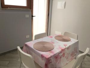 un tavolo rosa con sedie bianche e una tovaglia rosa di Sicily Sud-Est ad Avola