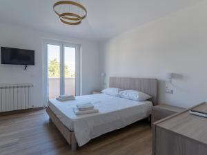 een witte slaapkamer met een bed en een raam bij Rupes House in Roccella Ionica