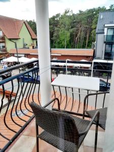 a balcony with chairs and tables on a building at Pokoje gościnne Rafa in Łeba