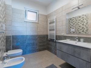 een badkamer met een wastafel, een toilet en een spiegel bij Rupes House in Roccella Ionica +58 foto's