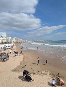 Un grupo de personas en una playa con el océano en Les Sables d'Olonne - Arago - Le 16, en Les Sables-dʼOlonne