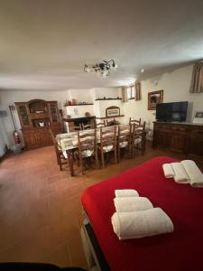 a room with a red bed with white towels on it at Oasi degli ulivi con piscina privata tra Versilia e Cinque Terre in Luni