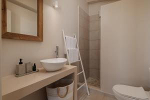 a bathroom with a sink and a toilet and a mirror at OPSTANTE Corfu in Benitses