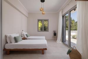 a white bedroom with a bed and a couch at OPSTANTE Corfu in Benitses