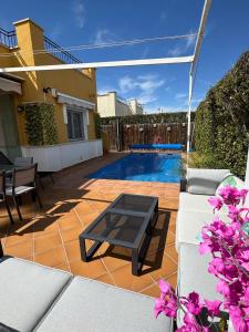 Un patio con una mesa y una piscina. en villa casa Aymlo, en Torre-Pacheco