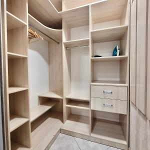 una cabina armadio con scaffali e armadi in legno di ApartPoltava Шикарна панорама ЦЕНТР апартаменти в елітній НОВОБУДОВІ, Документація для відрядження a Poltava Altre 9 foto