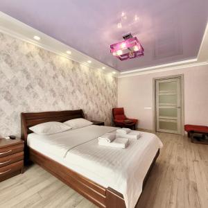 una camera da letto con un grande letto e un soffitto rosa di ApartPoltava Шикарна панорама ЦЕНТР апартаменти в елітній НОВОБУДОВІ, Документація для відрядження a Poltava