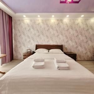 una camera da letto con un grande letto bianco con asciugamani sopra di ApartPoltava Шикарна панорама ЦЕНТР апартаменти в елітній НОВОБУДОВІ, Документація для відрядження a Poltava
