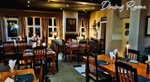 a dining room with tables and chairs in a restaurant at Silver Mist Guest House and Country Inn in Kaapsehoop