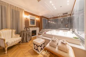 un ampio bagno con vasca e sedia di Tesoretto Hotel a Poggiardo