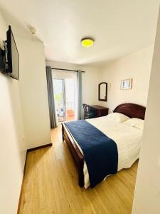 a hotel room with a bed and a sliding glass door at Residencial Santo António in Santa Cruz