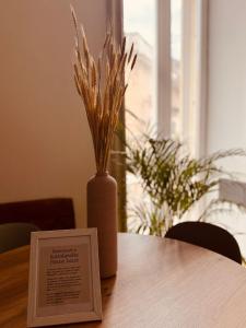 a vase with grass in it sitting on a table at Sottolavolta in Lecce