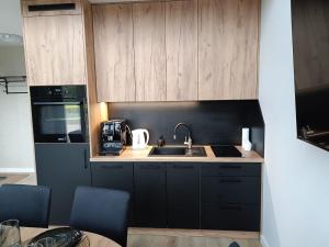 a kitchen with wooden cabinets and a sink at Pigwowcowe Zacisze in Grabowa