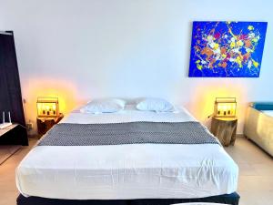 オリエントベイにあるLounge modern chill studio Orient Bayの壁に絵が飾られたベッドのある寝室 +45枚の写真