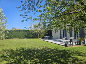 a backyard with benches and a grass yard at Maison Cosy Campagne, Spacieuse, Terrasse in Le Plessis-Feu-Aussoux