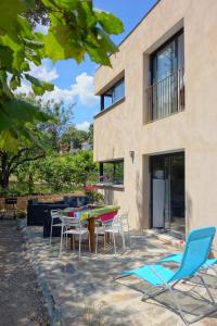 eine Terrasse mit Stühlen und einem Tisch vor einem Haus in der Unterkunft Le Clos Saint Elme in Collioure