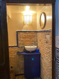 a bathroom with a sink and a mirror at Dar ZaZ in Fès