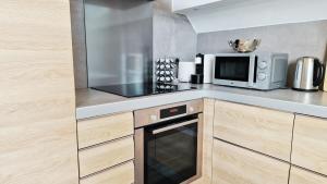 a kitchen with a microwave and a stove at Loft de Layolette, Laguiole centre, calme in Laguiole