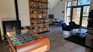a living room with a pool table and chairs at Loft de Layolette, Laguiole centre, calme in Laguiole
