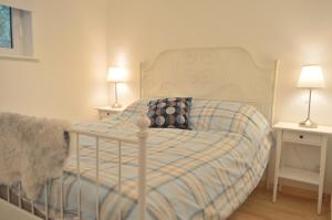a bed in a bedroom with two tables and two lamps at Spacious home in a tranquil village setting in Ockelbo