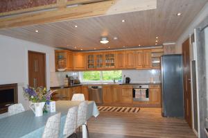 a kitchen with wooden cabinets and a table with chairs at Spacious home in a tranquil village setting in Ockelbo