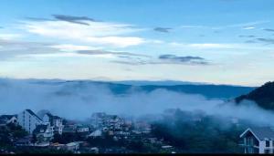 a city in the fog with mountains in the background at Villa Đà Lạt Trung Nghĩa in Ấp Ða Lợi
