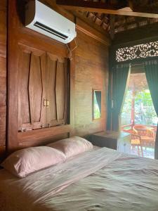 a bedroom with a bed with a air conditioner at Tebeduwe Joglo Villa in Mambat