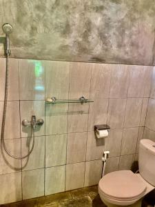 a bathroom with a shower and a toilet at Tebeduwe Joglo Villa in Mambat