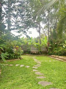 a garden with a stone path in the grass at Tebeduwe Joglo Villa in Mambat