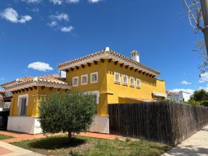 a yellow house with a fence in front of it at villa casa Aymlo in Torre-Pacheco