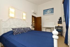 a bedroom with a bed with a blue comforter at Charming flat with shared pool in Peroj +8 photos