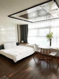 Un dormitorio con una cama y una mesa con sillas. en Nuzzone, en Seúl