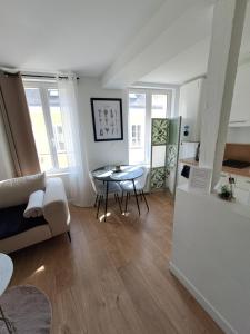salon ze stołem i kanapą w obiekcie Appartement de charme Rouen w Rouen