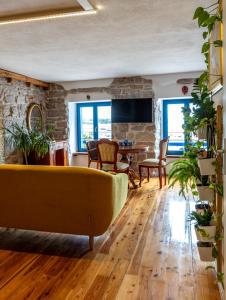 un soggiorno con divano giallo e pavimenti in legno di Old House a Vodice