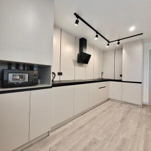 una cucina con mobili bianchi e un forno a microonde di ApartPoltava Graphite Luxe Ремонт 2025 Престижна новобудова в ЦЕНТРІ міста a Poltava