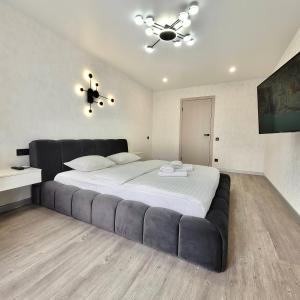 una camera da letto con un letto grande con un divano nero di ApartPoltava Graphite Luxe Ремонт 2025 Престижна новобудова в ЦЕНТРІ міста a Poltava