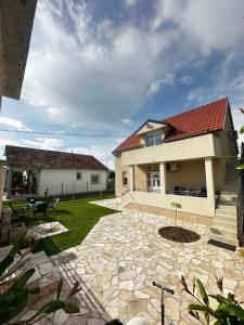 a house with a red roof and a patio at Airport Apartments MM in Golubovci