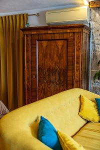 un divano giallo con cuscini blu davanti a una porta di Old House a Vodice