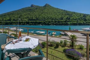 a balcony with a table and chairs and a body of water at Villa Dorijana, a beachfront holiday home in Plomin
