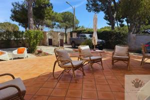 a group of chairs and an umbrella on a patio at Villa Rossi in Polignano a Mare