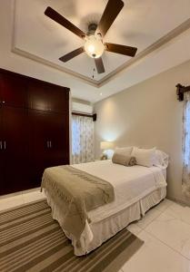 a bedroom with a ceiling fan and a bed at Tu hogar en Casa Valencia in San Pedro Sula
